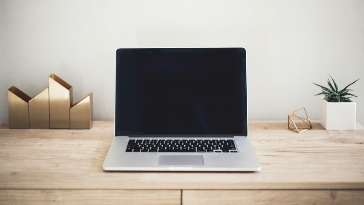 macbook pro on top of brown table