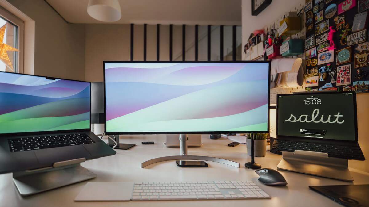 a desk with three computer monitors and a keyboard