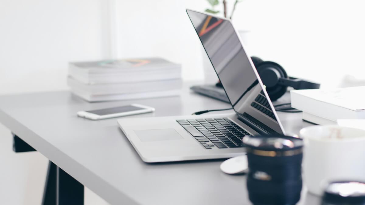 silver MacBook Pro on white table