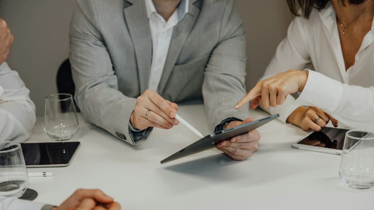 a group of people sitting around a table with a pair of scissors