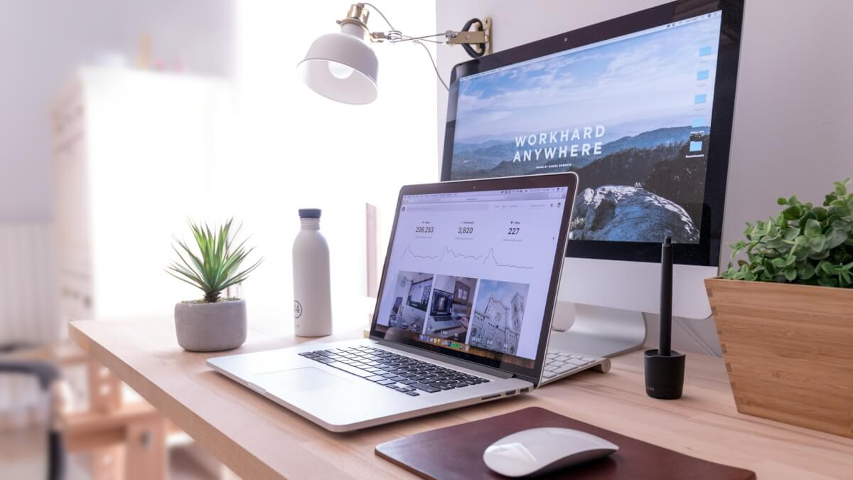 MacBook Pro on table beside white iMac and Magic Mouse