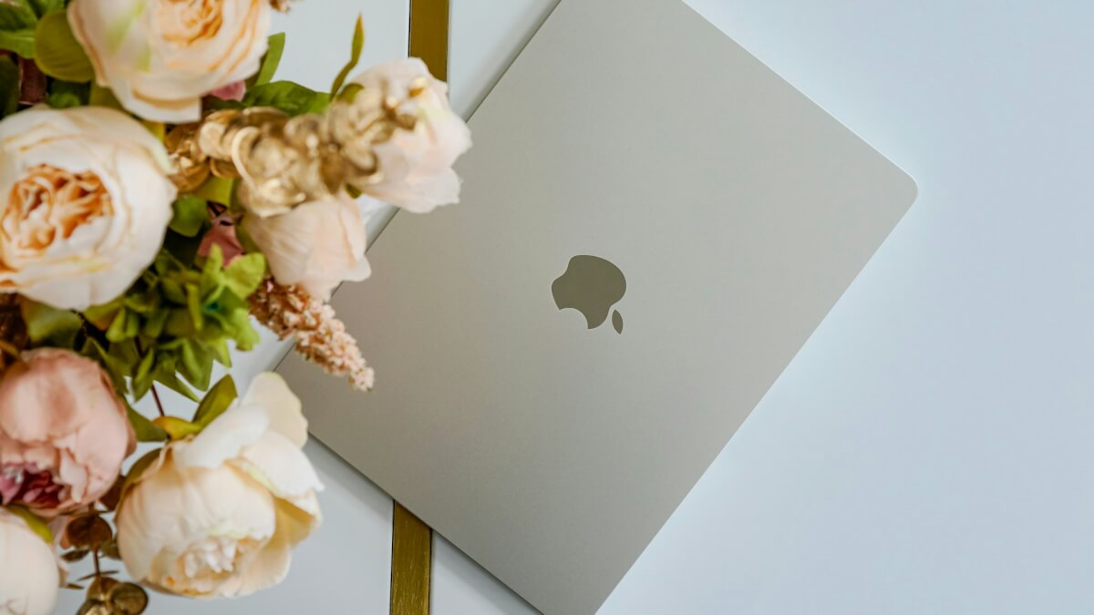 a bouquet of flowers next to an apple laptop