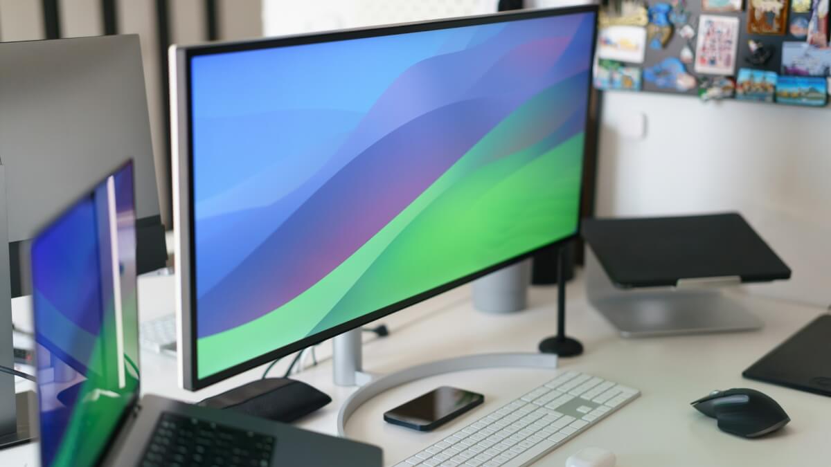 a desk with a computer monitor, keyboard and mouse