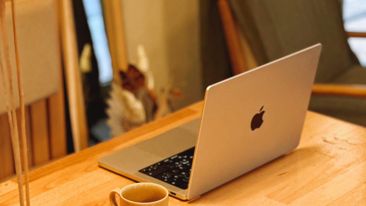 a laptop computer sitting on top of a wooden table