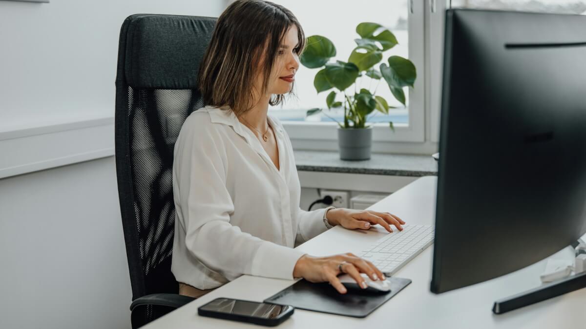 a woman sitting at a desk using a computer