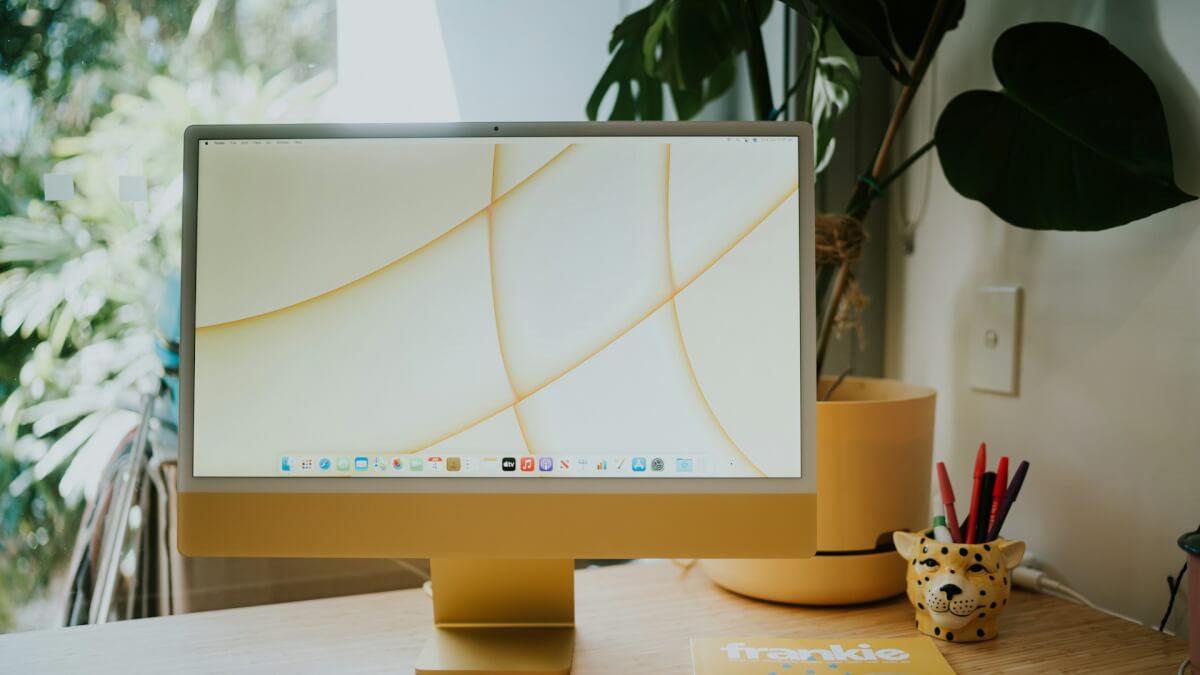 silver imac on brown wooden table