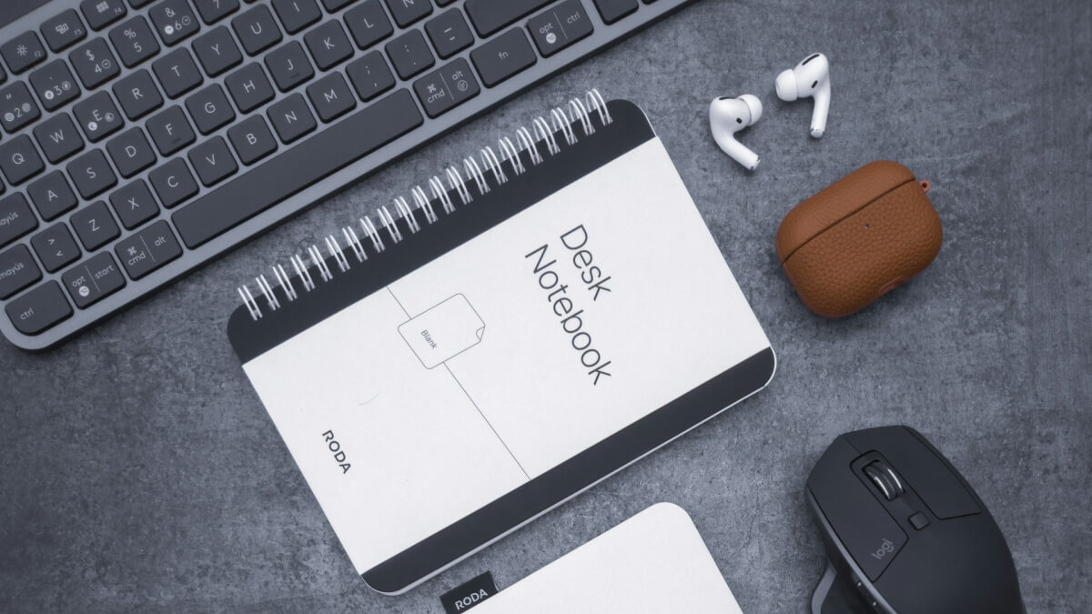 a desk with a keyboard, mouse, mouse pad and other items