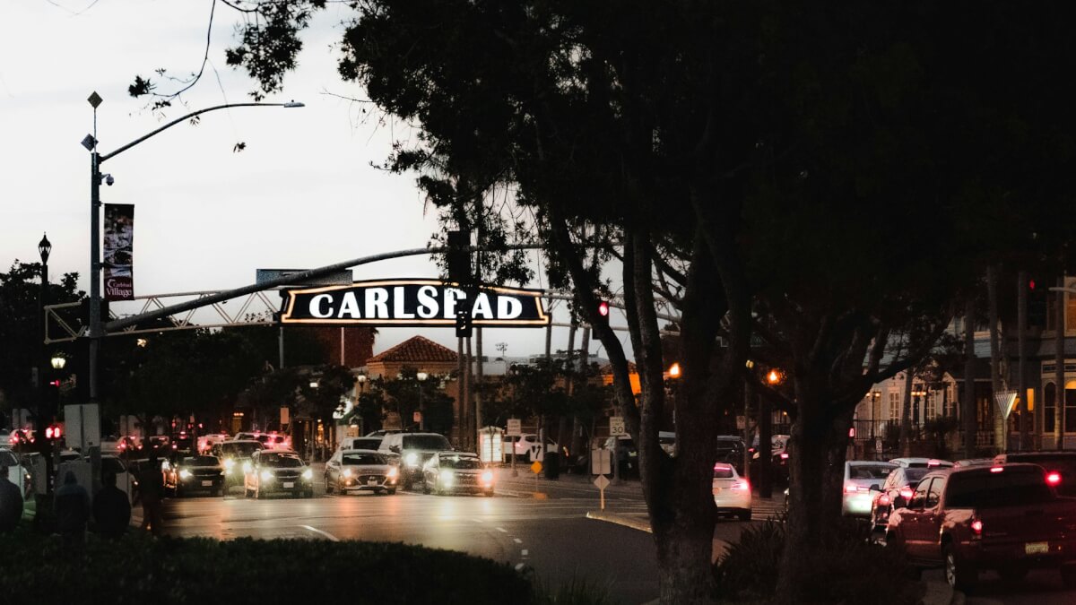 cars are driving down a busy street at night