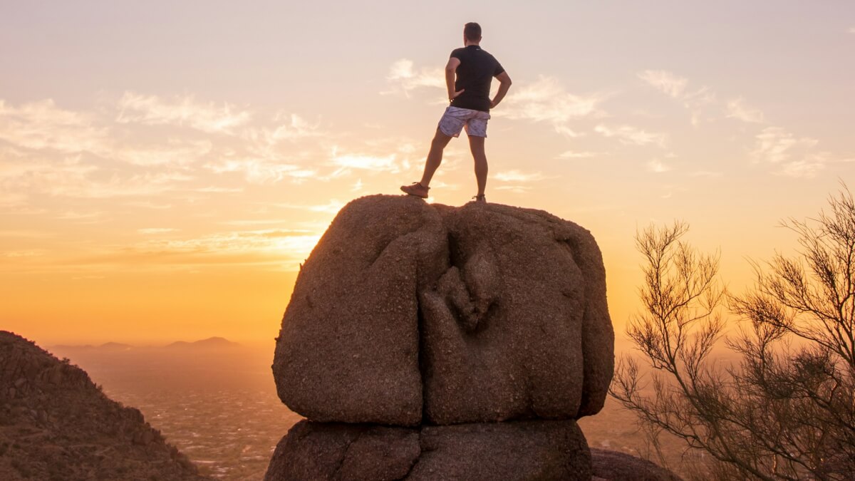 man standing on brown rock during daytime