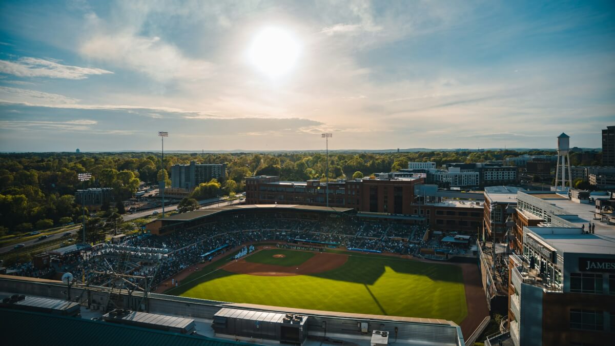 an aerial view of a baseball field with the sun in the background